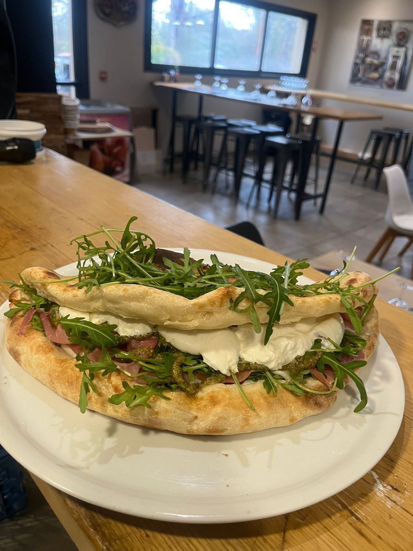 Pizza pliée garnie de burrata, jambon cru, pesto et roquette