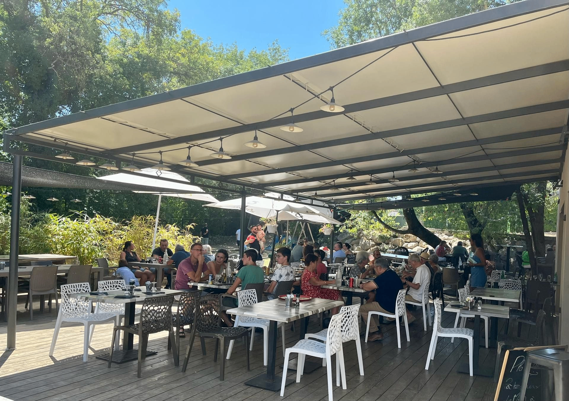 Terrasse ombragée de Chez Tony avec des tables en extérieur